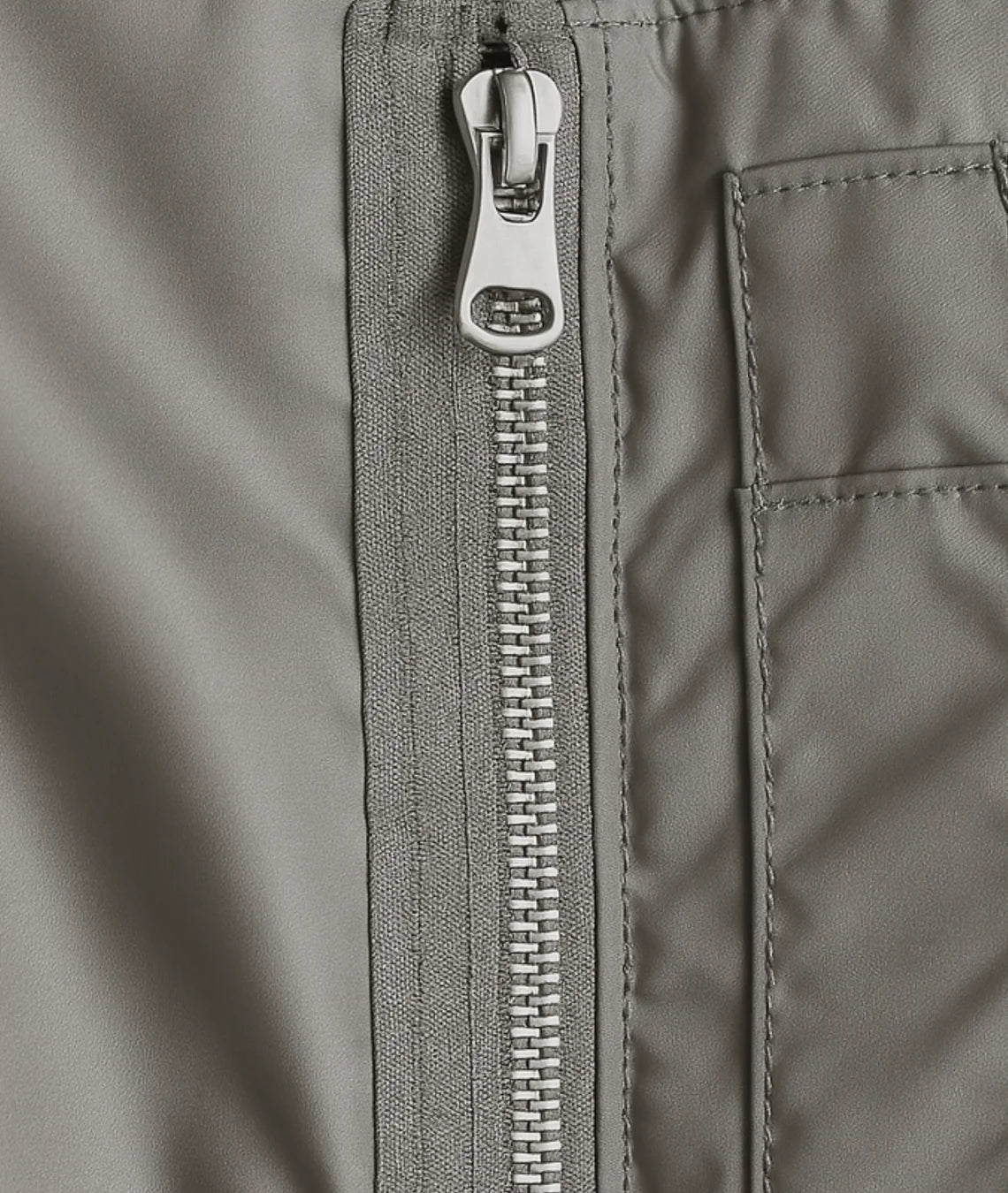 Close-up of a gray jacket zipper and pocket