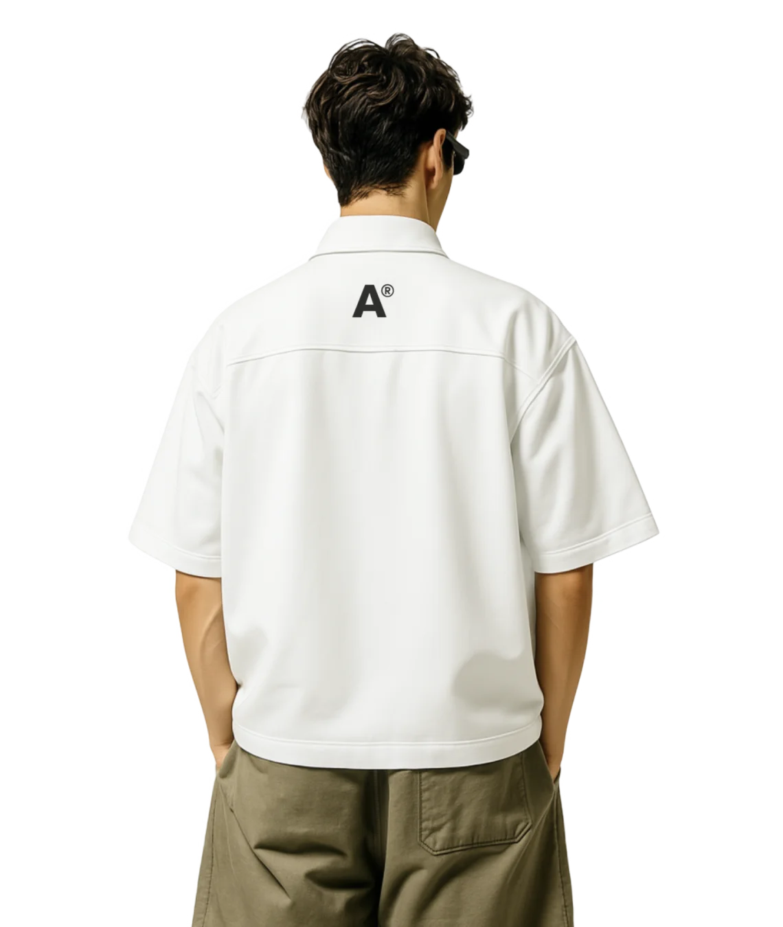 Person wearing a white shirt with a logo on the back, standing against a white background