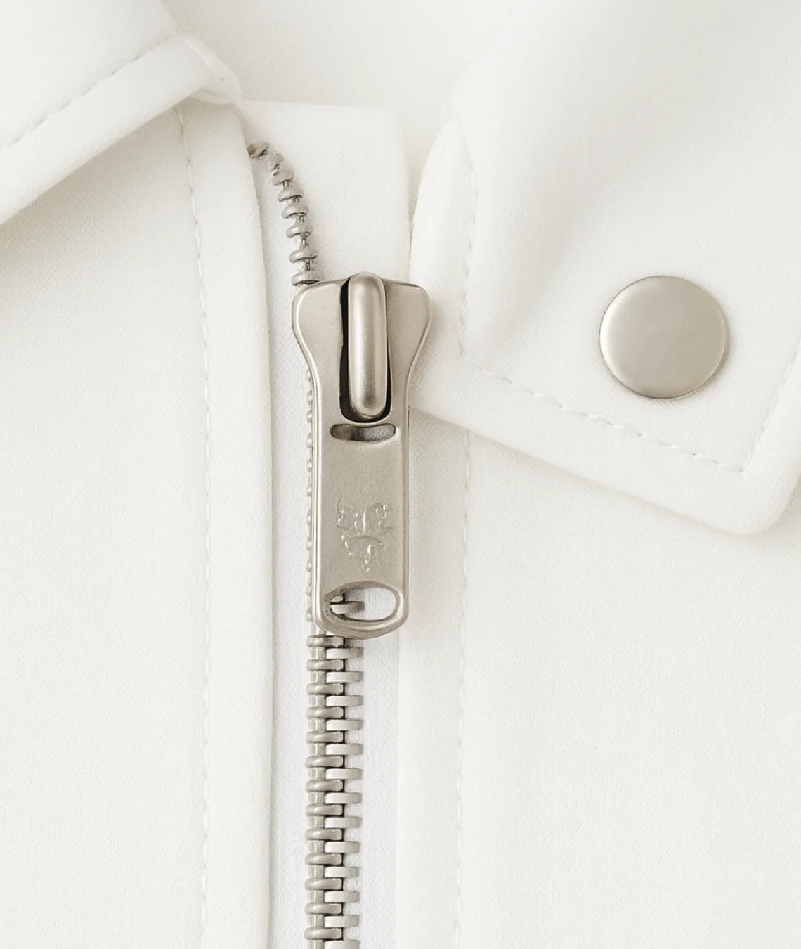 Close-up of a silver zipper on a white jacket
